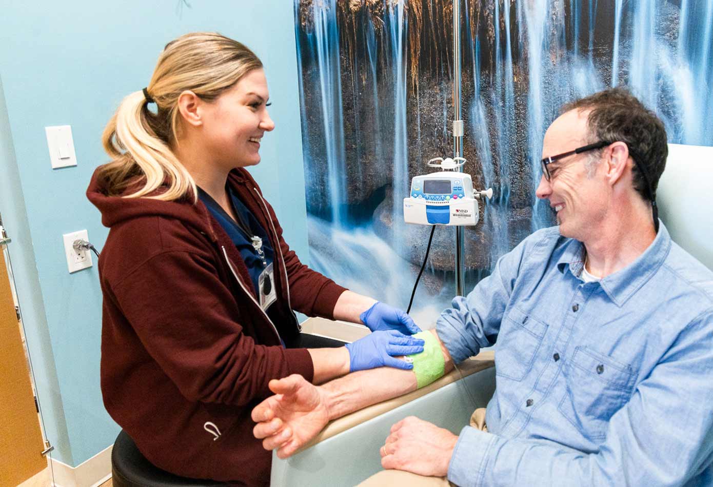 A nurse helps a man get an IV