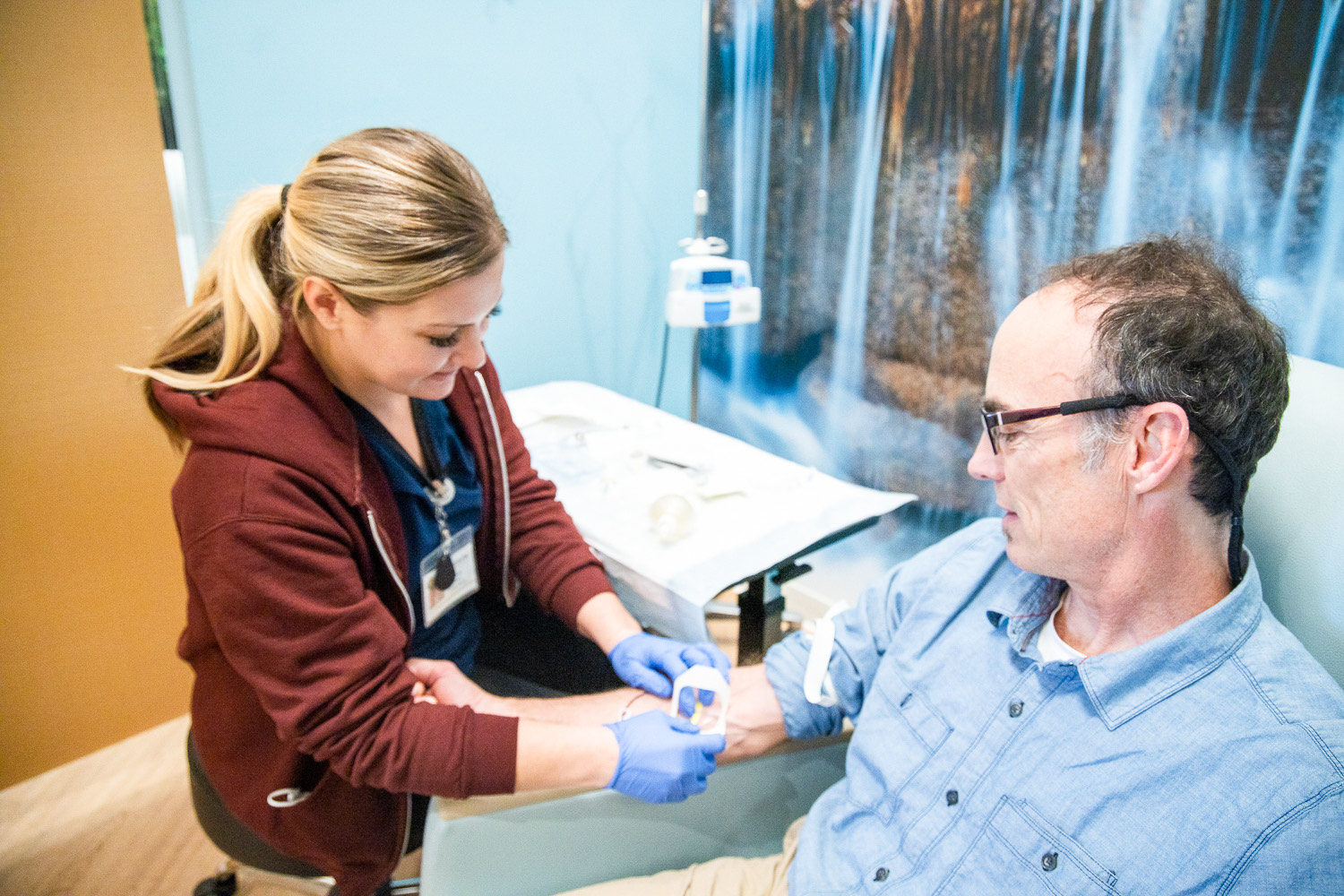 A nurse helps a man get an IV 